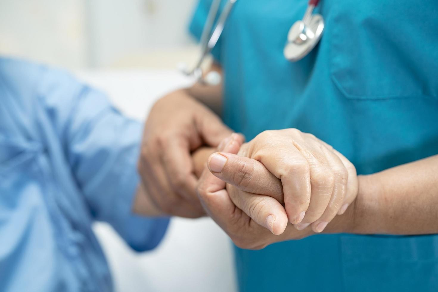 Nurse holding patients hands